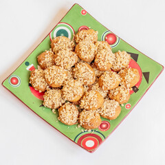 melomacarona plate, traditional Greek Christmas gourmet cookies with honey syrup and nuts on white background