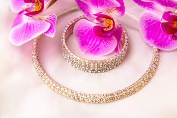 Bracelet and necklace on white fabric and purple Orchid
