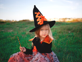 little girl dressed as a witch celebrates halloween
