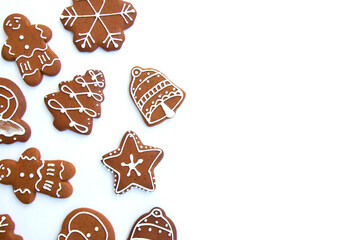 Tasty homemade Christmas gingerbread cookie of various shapes with sugar glaze on white background with copy space