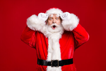 Photo of retire old man grey beard take off hold specs open mouth afraid forget presents home children wait wear santa costume belt gloves coat spectacles headwear isolated red color background