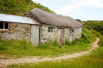 Fototapeta na wymiar An ancient, thatched, fisherman's hut, Prussia Cove, Cornwall, England, UK.