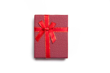 Red gift with a bow on a white background . Red bow. Bow on the gift. Gift wrapping. isolated background. Copy space. Article about gifts. New year and Christmas. Valentine's day.