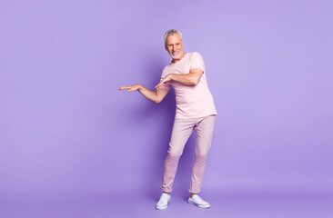 Full length photo of retired old man dance arms wear pink t-shirt pants sneakers isolated purple color background