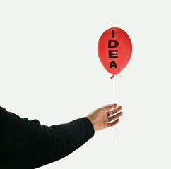Red balloon in man's hand. The concept of a new idea.