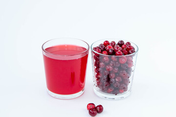 A glass of cranberry juice and a glass with red cranberries on a white background.
