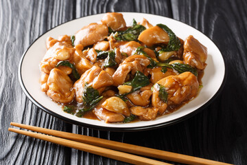 Three Cup Chicken, is a classic Taiwanese dish made by cooking chicken with sesame oil, soy sauce and rice wine close-up in a plate on the table. horizontal