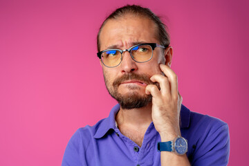 Confused bearded young man thinking about something
