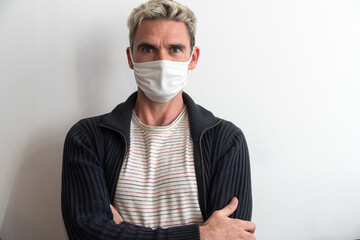 Homme occidental portant un masque blanc de protection pendant le confinement dû au coronavirus
