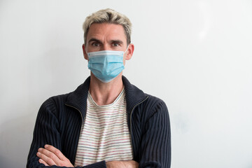 Homme occidental portant un masque bleu de protection pendant le confinement dû au coronavirus