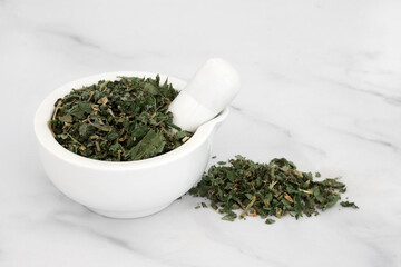 Pellitory of the wall herb in a mortar with pestle used in herbal medicine to treat fluid retention, urinary tract disorders, constipation, coughs and also used for burns and wounds on the skin.