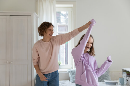 Overjoyed Caucasian Mom And 13s Teen Daughter Have Fun Dance On Weekend In Home Bedroom. Happy Loving Play Mother And Teenager Child Feel Playful Engaged In Funny Activity, Enjoy Family Time Together.