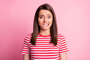 Fototapeta premium Portrait of stressed young lady bite lip wear tabby red white t-shirt isolated on pastel pink color background