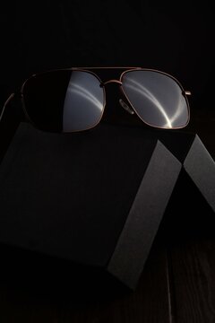 Brown Sunglass On The Black Case With Dark Background 