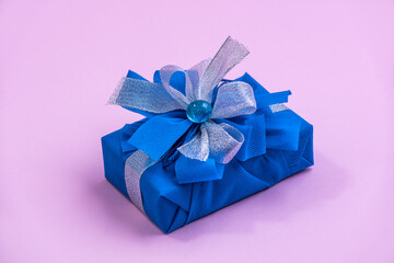 Classic blue surprise gift box with blue and white ribbon, background with copy space