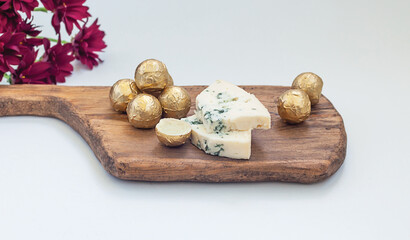 chocolate truffles made from white chocolate and dor blue cheese on a wooden board