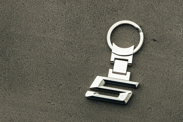 Metal number 5 car key on dark concrete background