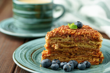 Piece of honey cake with nuts on green plate
