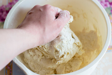 Kneading the dough with your hands. Hold the dough in your hands, knead, make buns