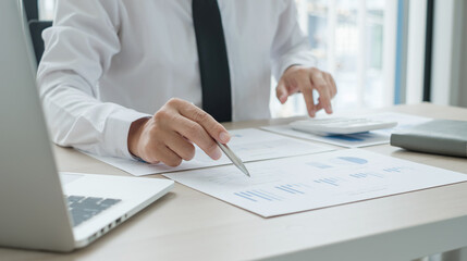 The businessman hand sits at their desks and calculates financial graphs showing the results of their investments planning the process of successful business growth