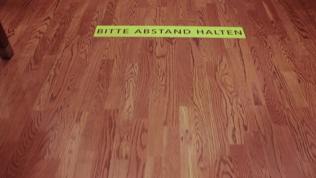 Walking over covid-19 "Bitte Abstand Halten" queue distance markers