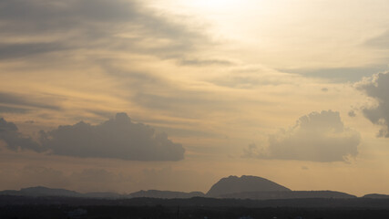 Silhouette of hills against beautiful golden hour light with wide angle and beautiful clouds formation
