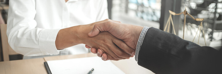 Lawyer consultant shaking hand with client in law firm.