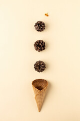Creative fall layout made with deconstructed ice cream, pine cone on vanilla background. Minimal autumn or Thanksgiving concept. Flat lay, greeting card.