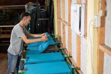 male workers prepare t-shirts placed on the board before screen printing