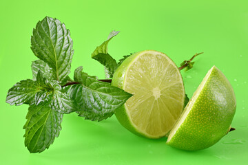 Lime with leaf mint on a green background.