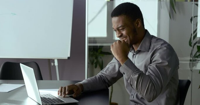 Portrait of overjoyed african american businessman looking at laptop screen, excited by unbelievable good news. Emotional ethnicity executive celebrating receiving attracted investment notification