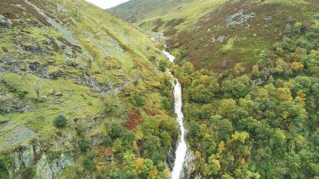 Idyllic Snowdonia mountain range Aber falls waterfalls national park aerial pull away fast view