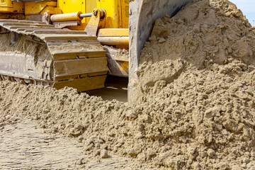 Fototapeta premium Crawler's tracks, bulldozer machine is leveling construction site