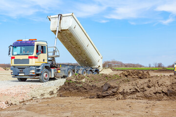 Obraz premium Tipper truck is unloading gravel from trailer