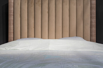 Bedroom, stylish made bed on a dark background. Getting ready to sleep.