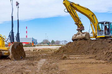 Excavator and earthmover are leveling ground construction site