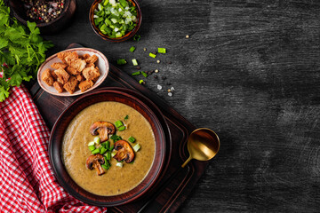  Plate of homemade mushroom cream soup on black background, top view, free space for text