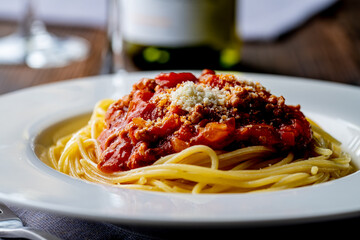 Pasta with meat and tomato sauce on wooden table.
Italian food concept.
