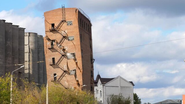 Industrial controlled explosion abandoned building on blue sky with white clouds background. Method for detonating used to set off dynamite bang blast include clearing city area
