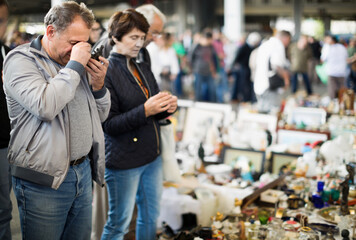 Portrait of mature male choosing vintage goods at flea market