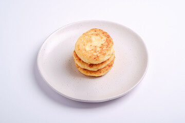 Cottage cheese fritters. Dessert breakfast in plate on white background, angle view