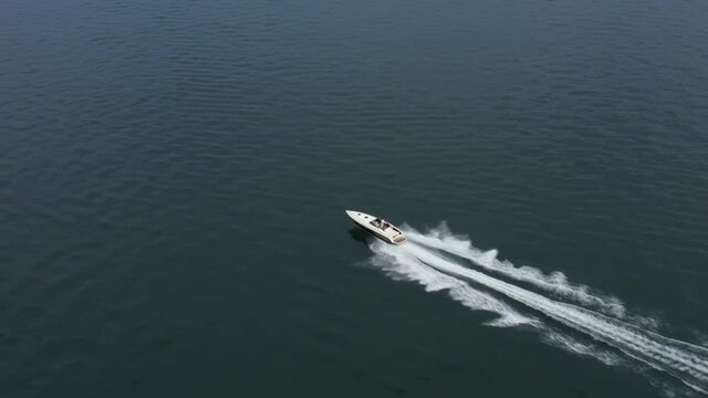 Large speed boat moving at high speed. Travel - image. Drone view of a boat  the blue clear waters. Top view of a white boat sailing to the blue sea.