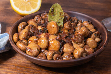 Vegan mushroom fricassee with garlic on a rustic background close-up - mushrooms with garlic, French cuisine.