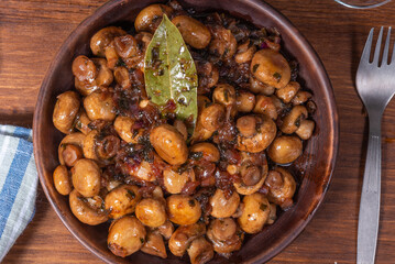 Vegan mushroom fricassee with garlic on a rustic background close-up, top view - mushrooms with garlic, French cuisine.