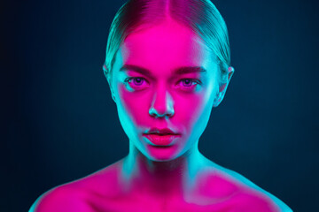 Tender. Portrait of female fashion model in neon light on dark studio background. Beautiful caucasian woman with trendy make-up and well-kept skin. Vivid style, beauty concept. Close up. Copyspace