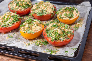 Provencal tomatoes - preparation of a dish, halves of tomatoes sprinkled with breadcrumbs, herbs and onions on a baking sheet