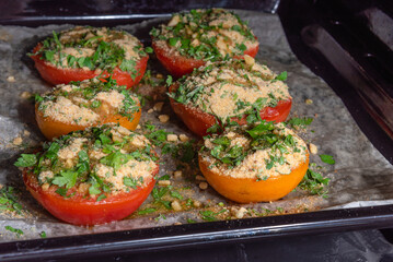 Provencal tomatoes - preparation of a dish, halves of tomatoes sprinkled with breadcrumbs, herbs and onions on a baking sheet