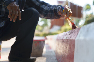 Asian worker painting no parking sign