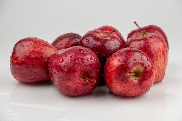 Pile of red apple with clear water drop on shell surface texture pattern isolated, white background