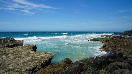 Fototapeta na wymiar Seascape with rocky shoreline, surf and blue sky